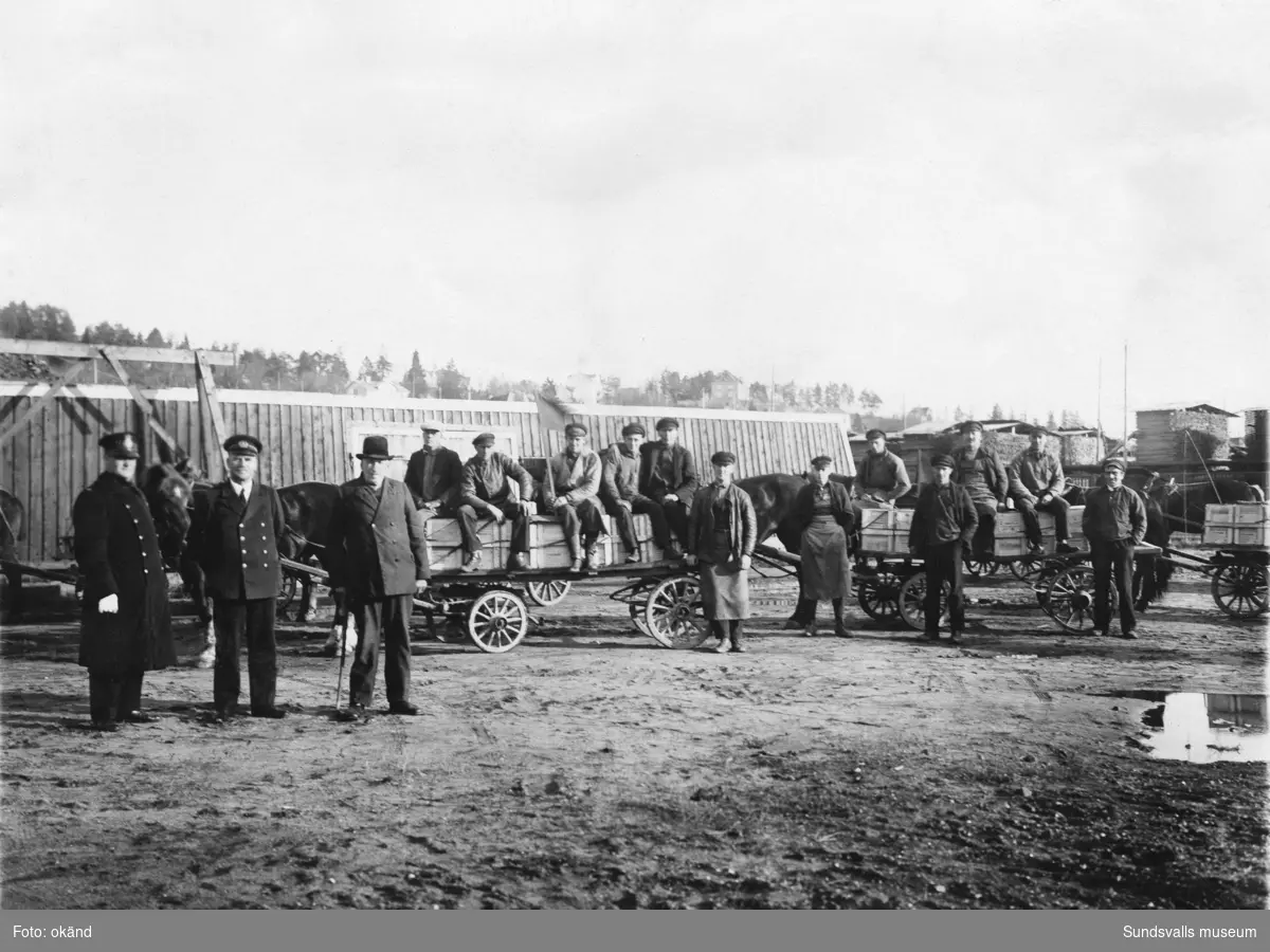 Dynamittransport med häst och vagnar på Norra kajen vid Heffners sågverk. Gustaf Andersson (f. 1898) sitter bredbent på flaket till vänster. En polis vid namn Sahr står till vänster.