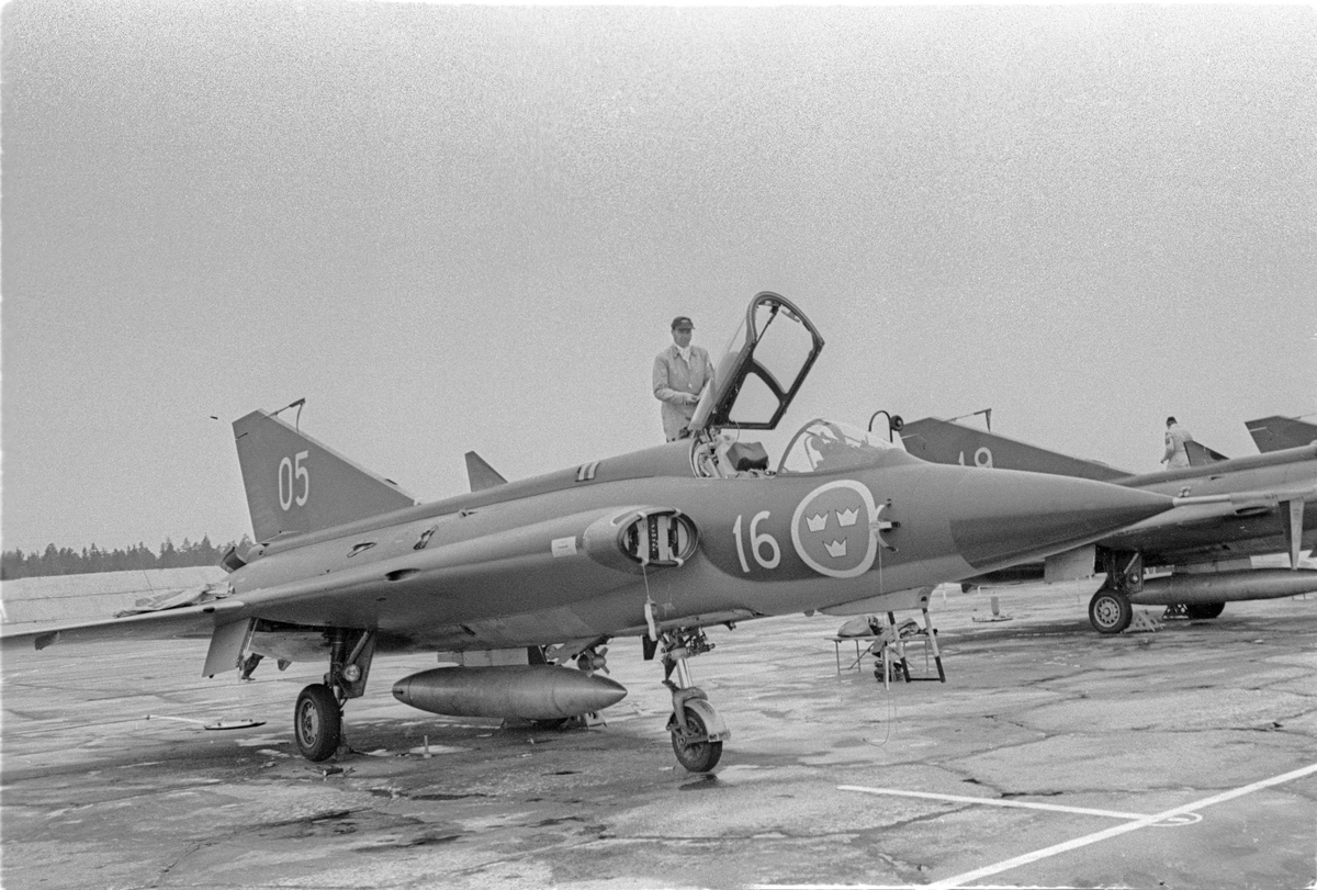 Flygplan J 35 Draken uppställd på sovjetisk flygbas. En man står vid huven. Vid Kungliga Upplands flygflottiljs besök vid sovjetisk MiG-21-bas den 16 mars 1972.