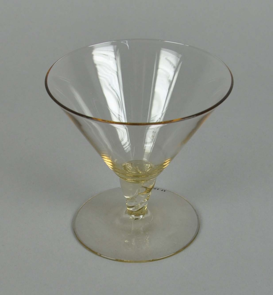 Coctailglass av gult glass. Glasset har y-form med spiralisert stett.