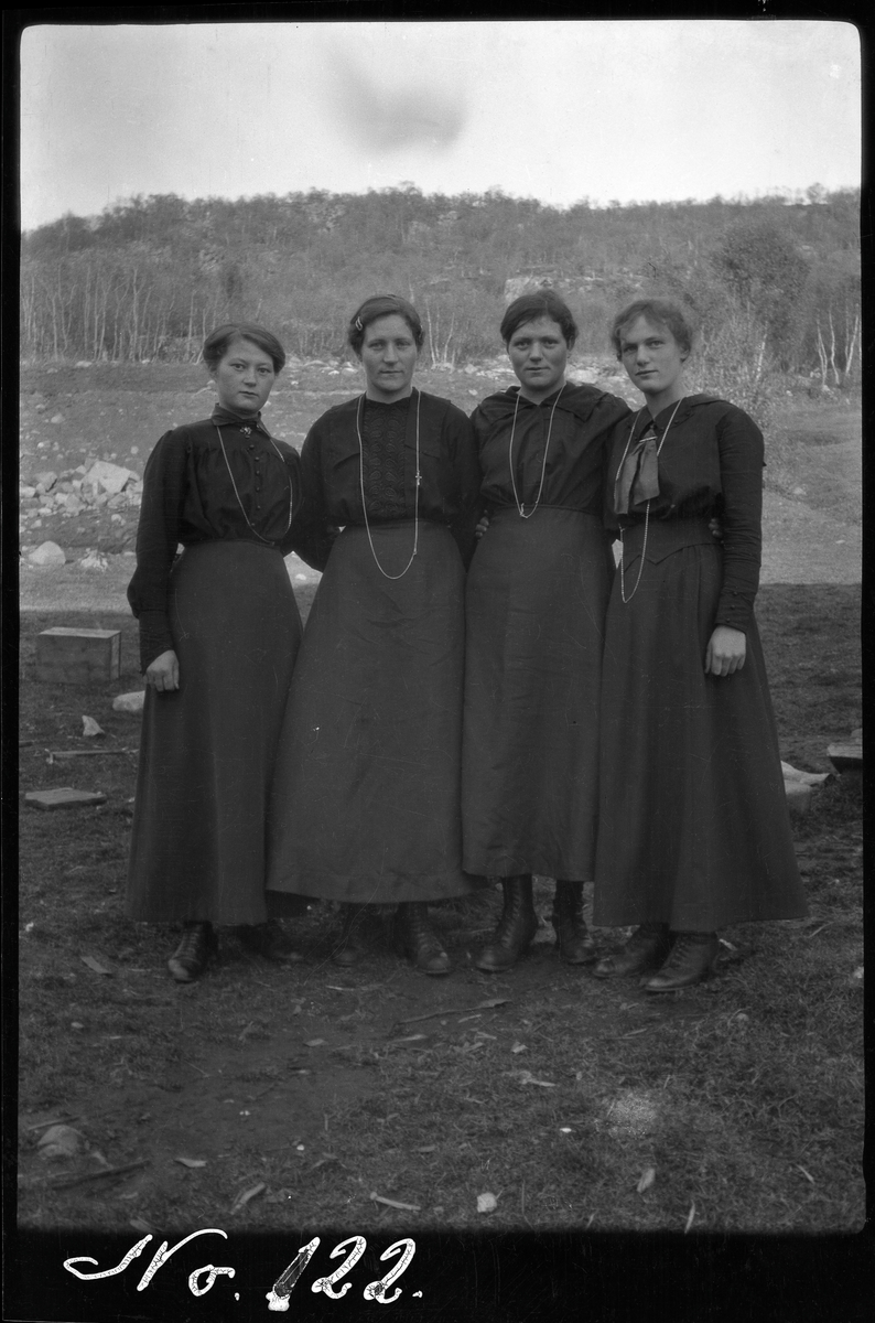 Gruppebilde av fire kvinner, fotografert stående utendørs.
