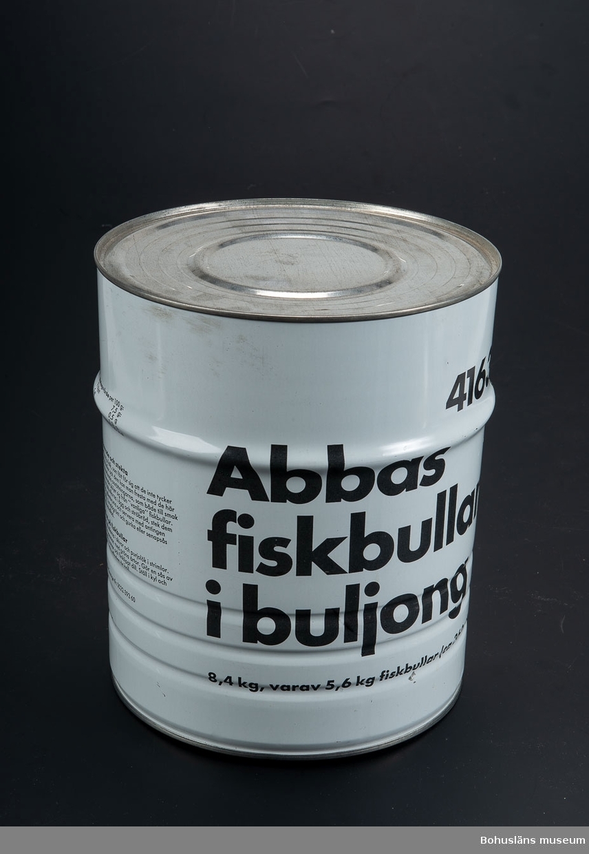 Cylinderformad burk i vitt med tryckt text i svart direkt på plåten. Text: "Abbas fiskbullar i buljong. 8,4 kg varav 5,6 kg fisk bullar (c;a 360 st)" och "4163" samt innehållsdeklaration.