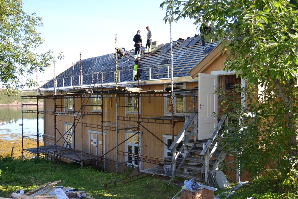 Leirfjord, Nedre-Leland. Entreprenørfirmaet, Einmo, legger om taket på Bergh-brygga (museet). Taksteinen begynner å komme på plass på taket igjen, etter ny takpapp er lagt på og opplekting. Nye takrenner er montert.