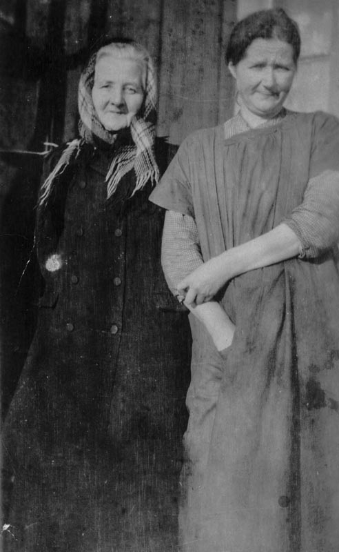 Leirfjord, Moen. To damer fotografert, den ene i kåpe og hodetørkle, den andre barhodet og i kjole. F.v.: Johanna S..h...eig (1861-1947) og Oline Moen.