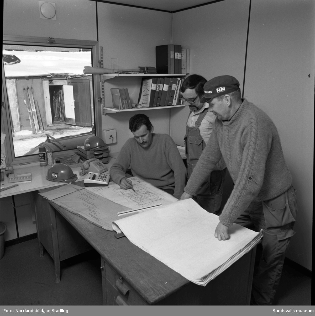 Byggkontor i Granloholm, tre män planerar arbetet.