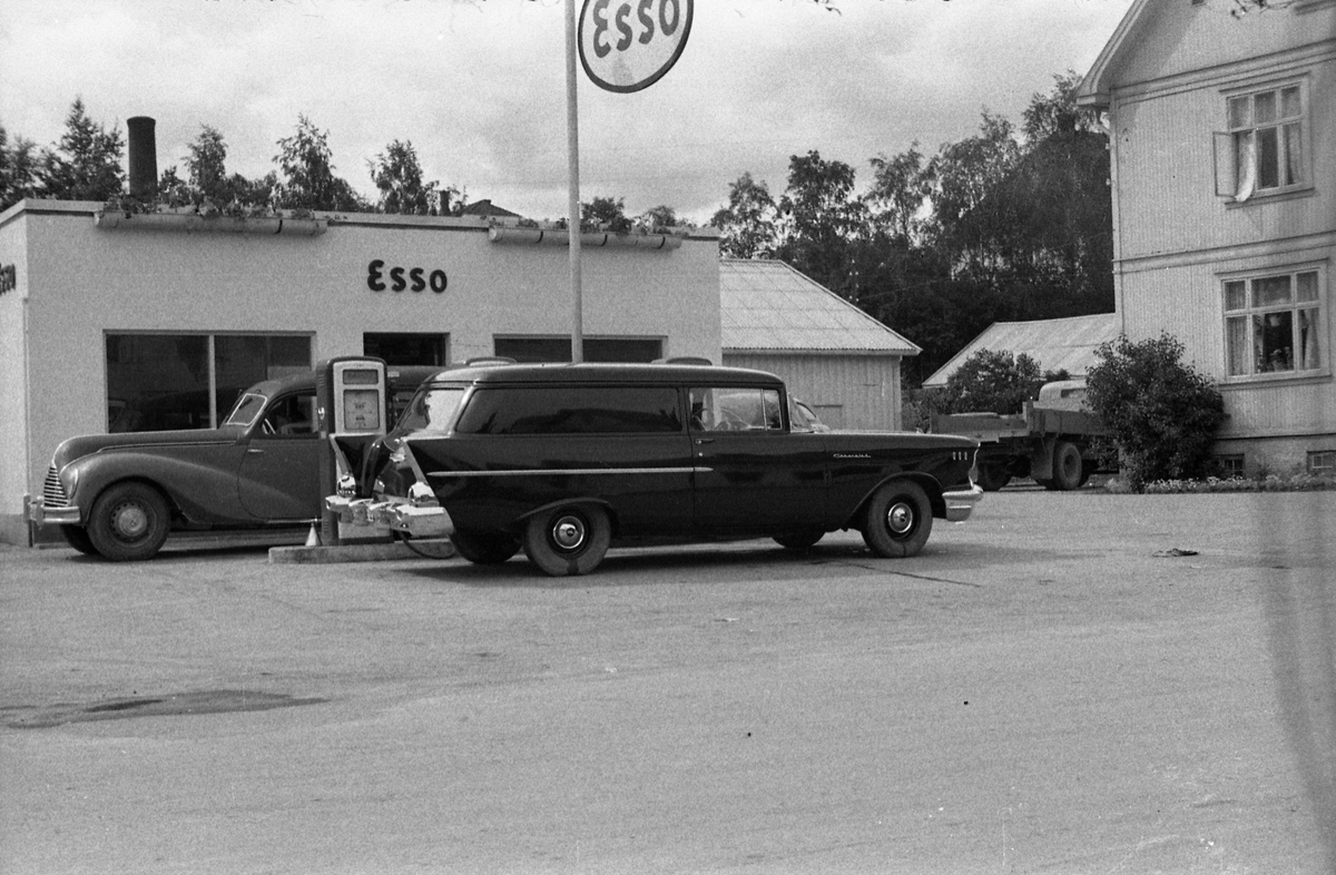 To biler ved Esso bensinstasjonen på Lena, juni/juli 1956. Ifølge informant er bilene en EMW (Øst-Tysk BMW) fra tidlig 1950-tall, og en Chevrolet varevogn 1957-modell.