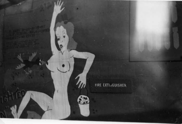En naken kvinna målad på ett amerikanskt bombplan, i handen tappar hon en hink med bär när en fågel biter hennes bröstvårta, som ser ut som ett bär.