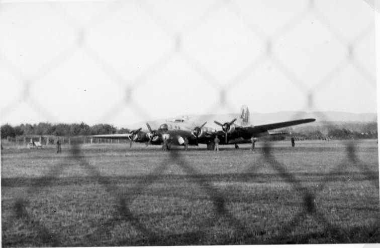 Ett amerikanskt bombplan som nödlandat på Jönköpings flygplats. Sedd genom ett stängsel.