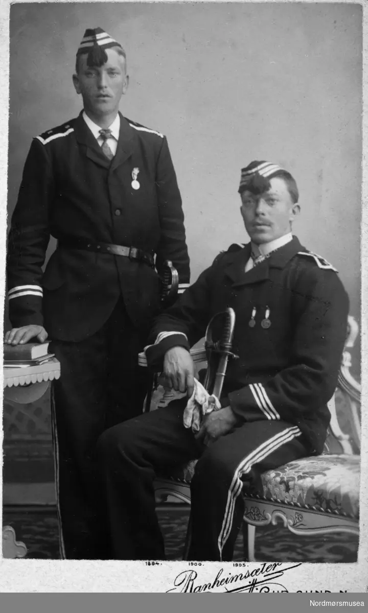 Foto av to menn i uniform og sverd. Fra et fotoalbum som stammer etter Marie Opdal (f. april 1894 - d. februar 1981/82), gitt i gave av Torbjørg og Arild Karijord. Fra Nordmøre museums fotosamlinger.