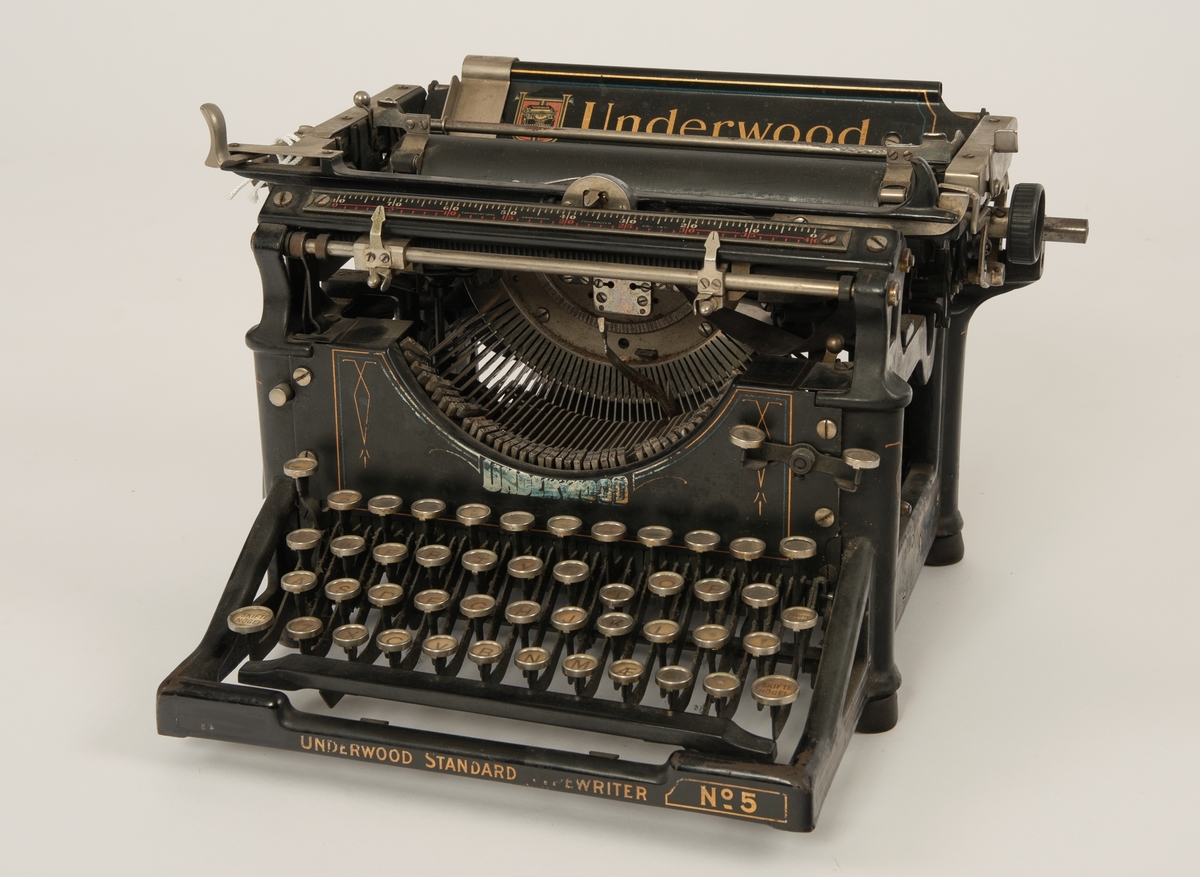 Mekanisk skrivemaskin med dekor i gull.