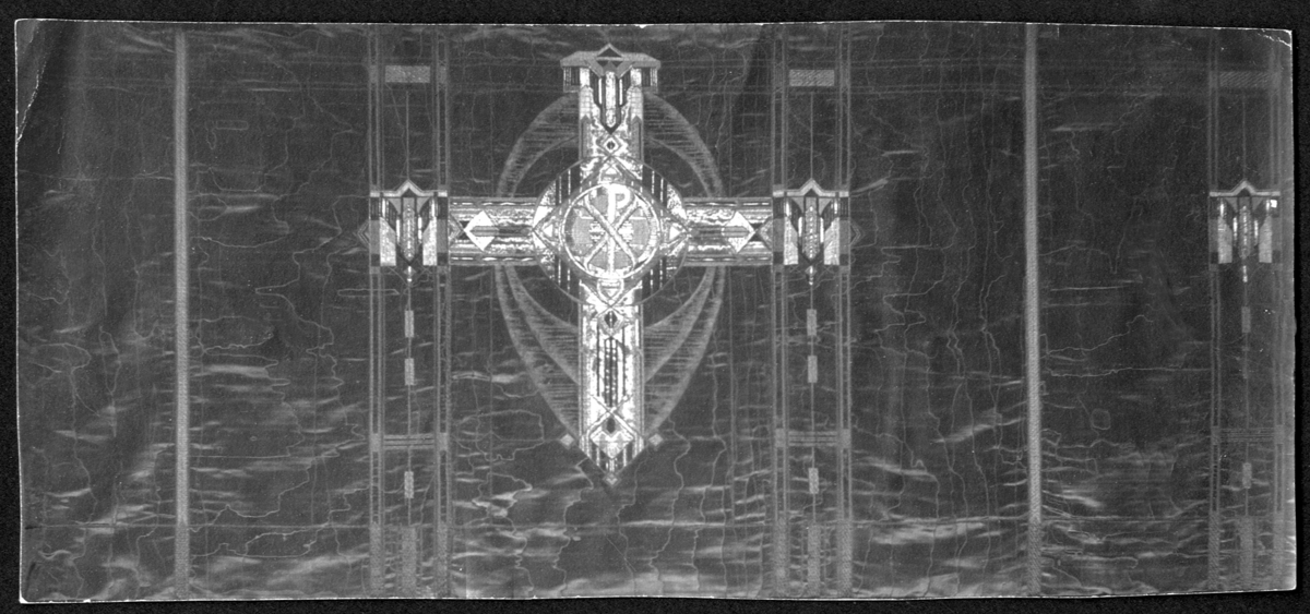 Foto (svart/vitt) av ett antependium i mörkt siden, broderat med metalltråd. I mitten ett liksidigt kors med Kristusmonogram. 

Inskrivet i huvudbok 1983.