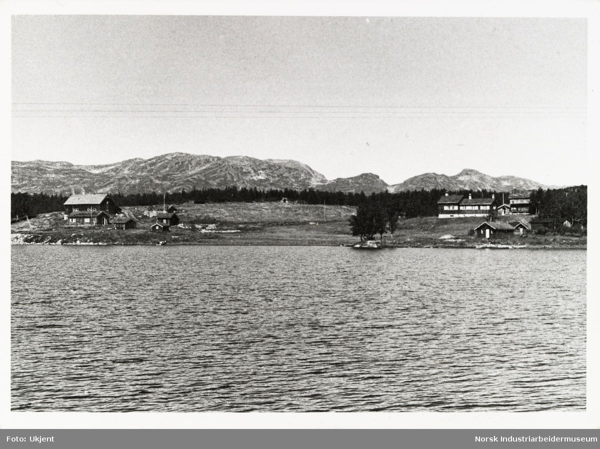 Utsikt mot Sundet fra innsjøen Møsvatn. Bebyggelse ved vannkant, høye fjell sees i bakgrunn