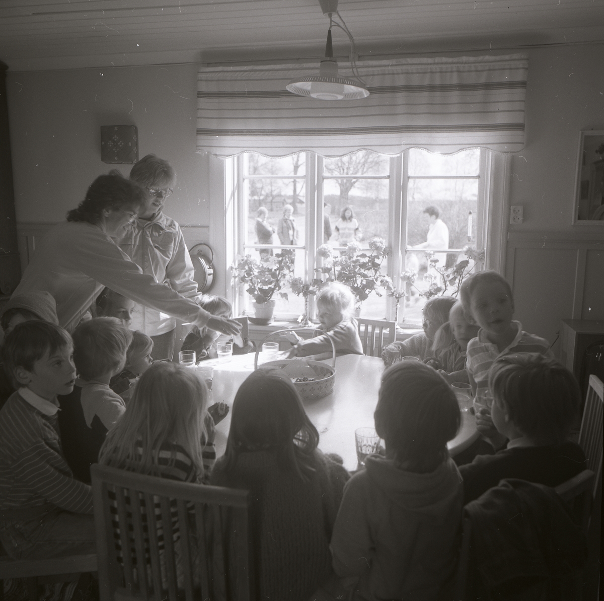 En grupp barn har samlats runt ett bord för att fika, 14 maj 1986.