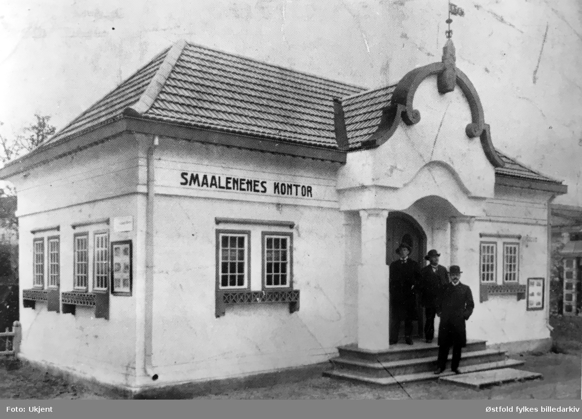 Smaalenenes kontor, antakelig på Jubileumsutstillingen i Frognerparken i Kristiania 1914. Mennene er ukjente.