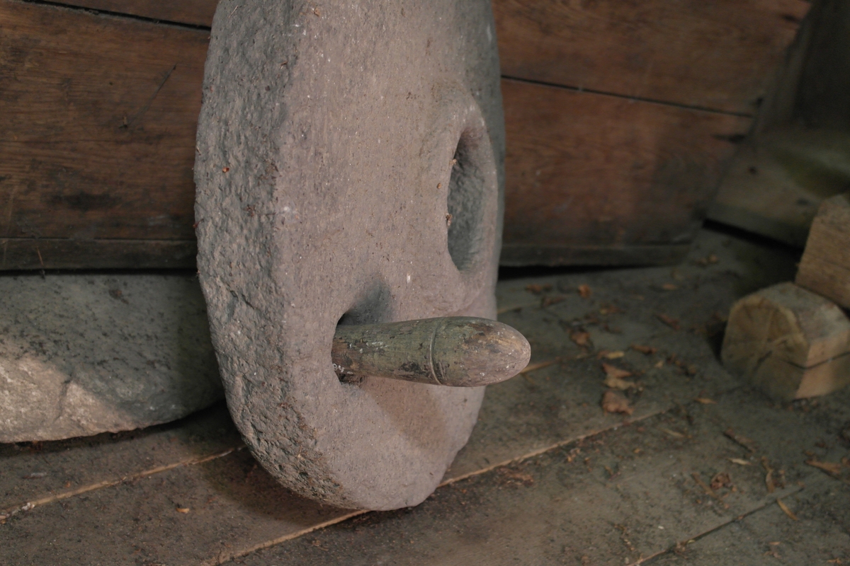 Innekvern som er demontert. Består av to kvernsteiner (a-b) i hogget stein og et løst håndtak i dreiet eik.