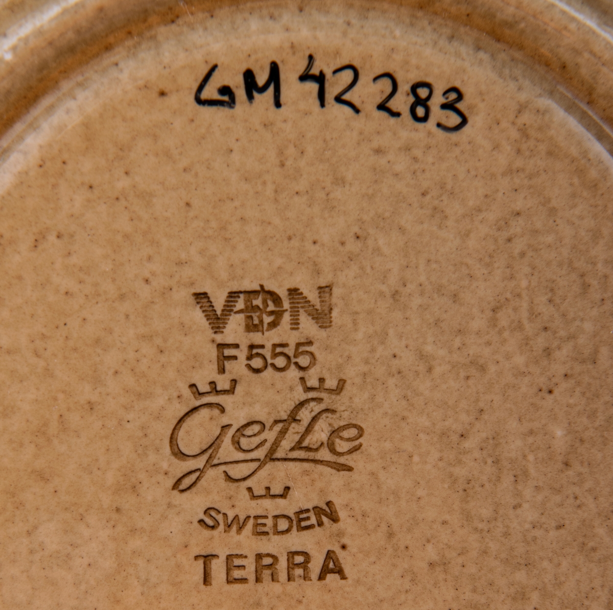 Kaffekopp modell EH, dekor Terra, modell och dekor av formgivare Berit Ternell. Gulbrun glasyr med ljusbrunt och mörkbrunt band.