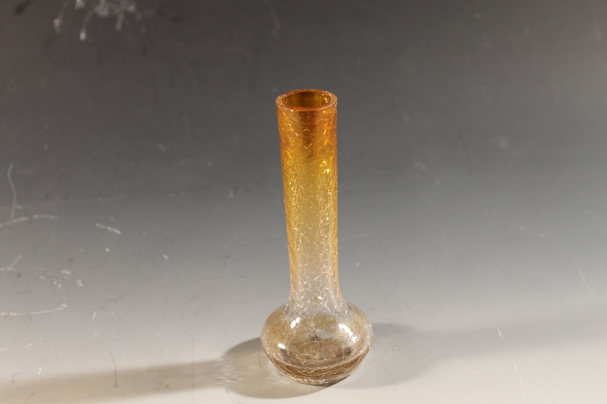 Form: liten vase, flattrykt vuslst i bunnen, smalner til tynn hals
