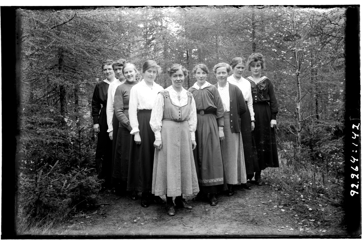 Hålahult sanatorium, exteriör, nio kvinnor på en stig i skogen, civila kläder.