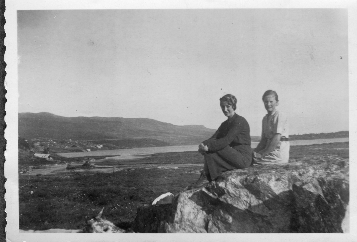 To damer sit på ein stein ved Brandthytta i Kvitehaugen.