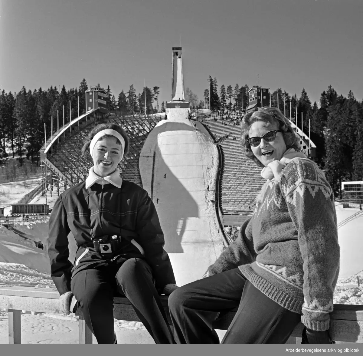 "Mor og datter, Ingrid og Ingebjørg Vestgren, koser seg i påskesola i Holmenkollen". Mars 1962.