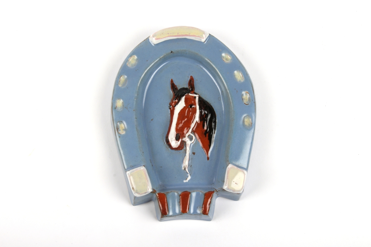 Askebeger formet som en hestesko med hestehode i midten som relieffdekor.