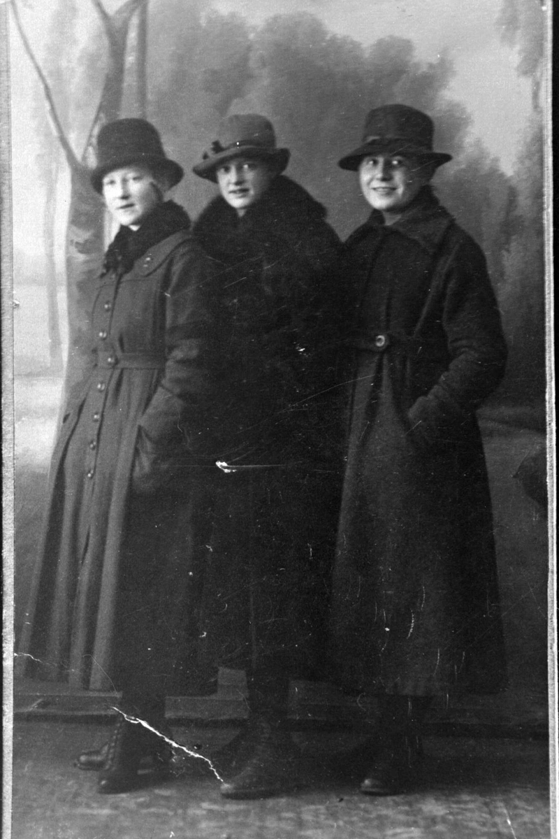 Studioportrett av tre kvinner i vinterklær.