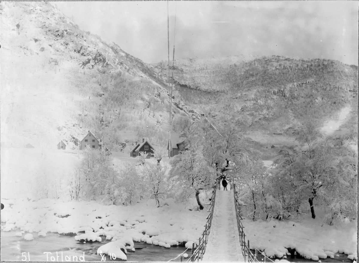 Hengebro over elv til Totland. Person i andre enden av broen vinterstid
Utbygging av Bergen Kraftanlæg i Samnanger