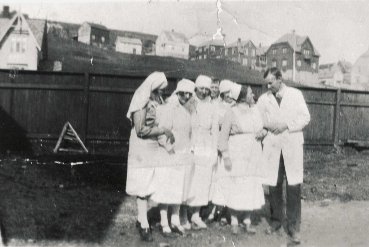 Gruppebilde av sykesøstre og leger på gårdsplassen utenfor Harstad sykehus.