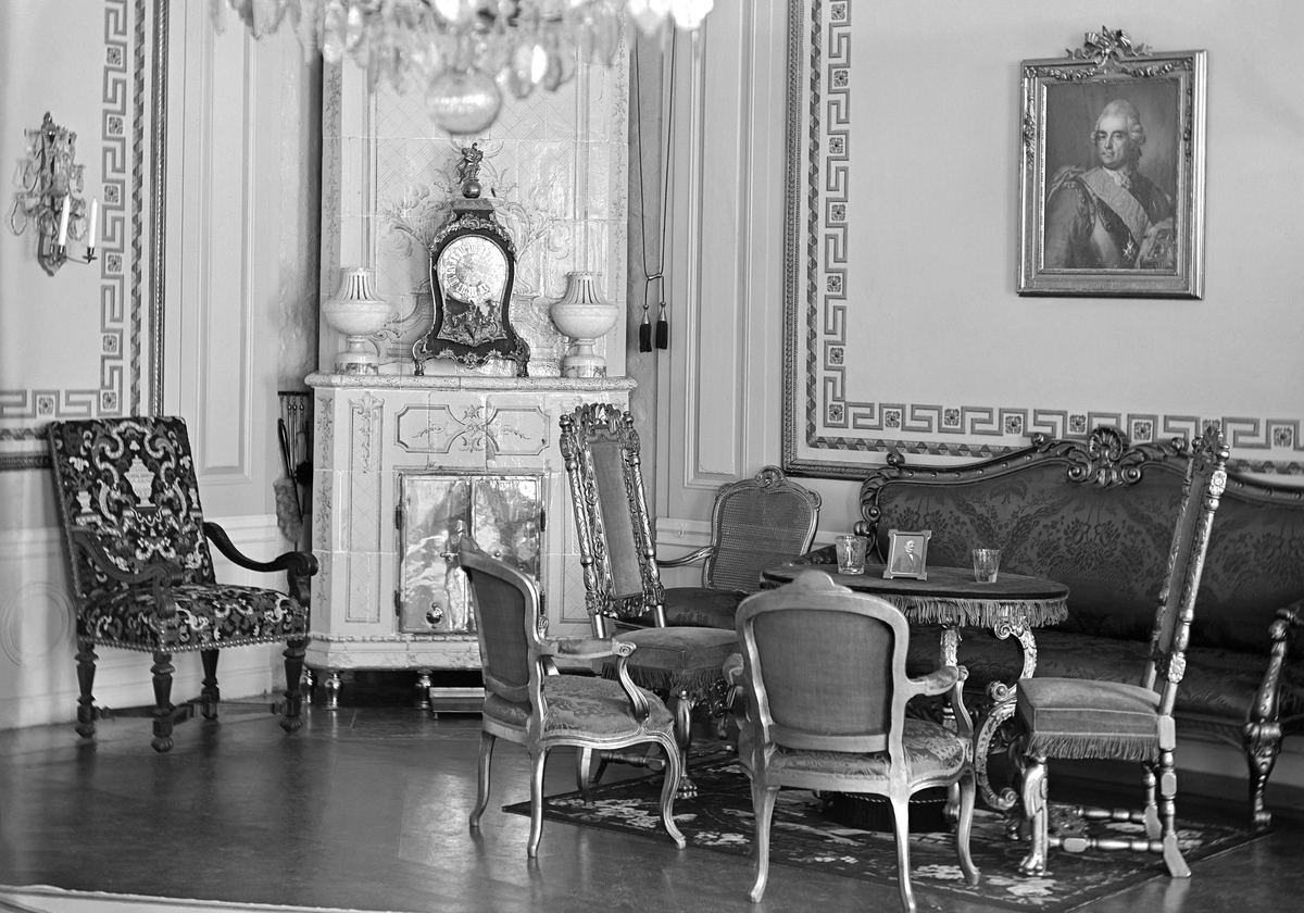 Interiör från Thorönsborgs slott. De vävspända väggfälten i salongen är dekorerade med strama meanderbårder av gustaviansk karaktär likaså den rikt dekorerade kakelugnen med en sittgrupp i både rokoko och barock stil intill.