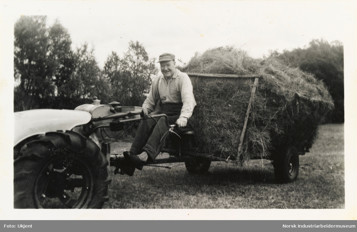 Olav Kvammen sittende på traktor med høyvogn i Kvammen