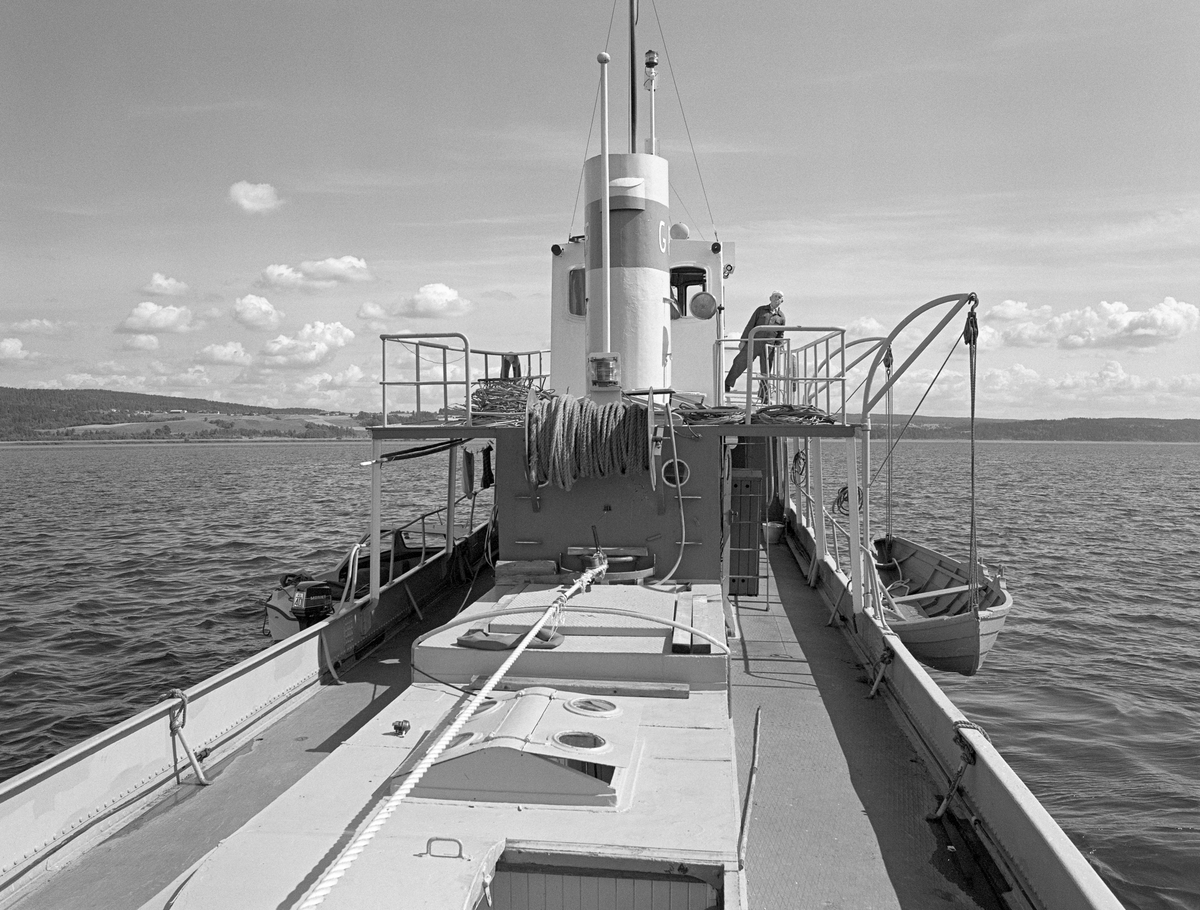 Akterdekket på slepebåten M/B Mørkfos på innsjøen Øyeren, der den i perioden fra 1912 til 1985 slepte tømmer fra Fetsund i nord til Sleppetangen og Sandstangen i sør. Mørkfos er 72 fot lang, og var den største båten i sitt slag på Øyeren.  Den ble bygd ved Glommen mek. verksted i Fredrikstad i 1912.  Oppdragsgiver var Fredrikstad tømmerdireksjon, som på denne tida organiserte tømmerfløtinga i Glommavassdraget sør for Fetsund.  Fra 1920 ble organisasjonen kalt Nedre Glommen fellesfløtningsforening.  Tidlig i 1940-åra ble tømmerfløtingsorganisasjonene i den øvre og den nedre delen av vassdraget slått sammen i Glomma fellesfløtingsforening.  Denne organisasjonen opptrådte som rederi for Mørkfos og en rekke andre slepebåter inntil fløtinga i vassdraget ble avviklet i 1985.  Mørkfos var opprinnelig dampdrevet, men i 1953 ble dampmaskinen tatt ut og erstattet av en tresylindret dieselmaskin, en Wickmann-motor.  Dermed ble båtens navn endret fra "D/S Mørkfos" til "M/B Mørkfos".   For ledelsen i Glomma fellesfløtingsforening var det antakelig viktigere at en etter denne ombygginga kunne redusere størrelsen på mannskapet noe.  Opprinnelig hadde det vært sju faste om bord: Skipper, to maskinister, tre dekksgutter og kokke.  Etter ombygginga til dieseldrift hadde Mørkfos et mannskap på fire-fem.  Den opprinnelige Wickmann-motoren fra 1953 ble for øvrig erstattet av en MWM-maskin (fra Motoren-Werke-Mannheim i den tyske delstaten Baden-Würtemberg) i 1966.  Mørkfos ble brukt til å slepe tømmer over Øyeren fra lensene på Fetsund i nord til Sandstangen i sør.  Der ble slepene med "sopper" (bunter) løst opp, og stokkene fikk gå fritt et stykke videre nedover i vassdraget, der det skulle passere flere kraftverk i trange tømmerrenner før det på nytt ble lenset, sortert og slept videre nedover vassdraget. 

Etter at fløtinga i Glommavassdraget ble avviklet ble M/B Mørkfos liggende ubrukt ved Fetsund lenser, der den forfalt.  I 1994 startet en venneforening et omfattende restaureringsarbeid, som ble støttet av Riksantikvarens avdeling for fartøyminnevern.  I 2004 ble restaureringsarbeidet belønnet med kulturvernprisen til Oslo/Akershus avdeling av Fortidsminneforeningen.  Båten drives av venneforeningen, som tilbyr sommerturer på Øyeren, med avganger fra lensemuseet på Fetsund.