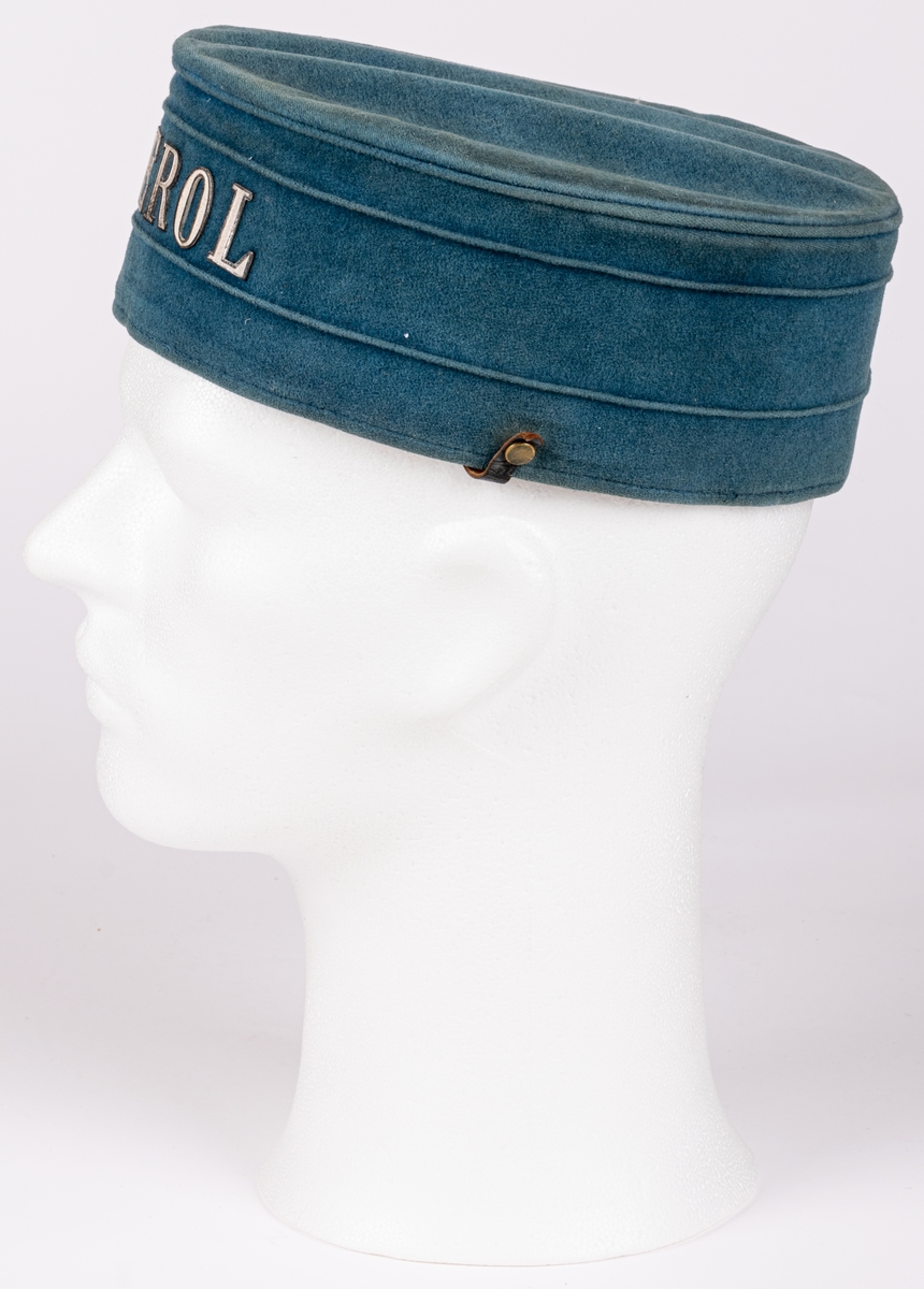Hatt i blå sammet med text i metall: "LÄKEROL".