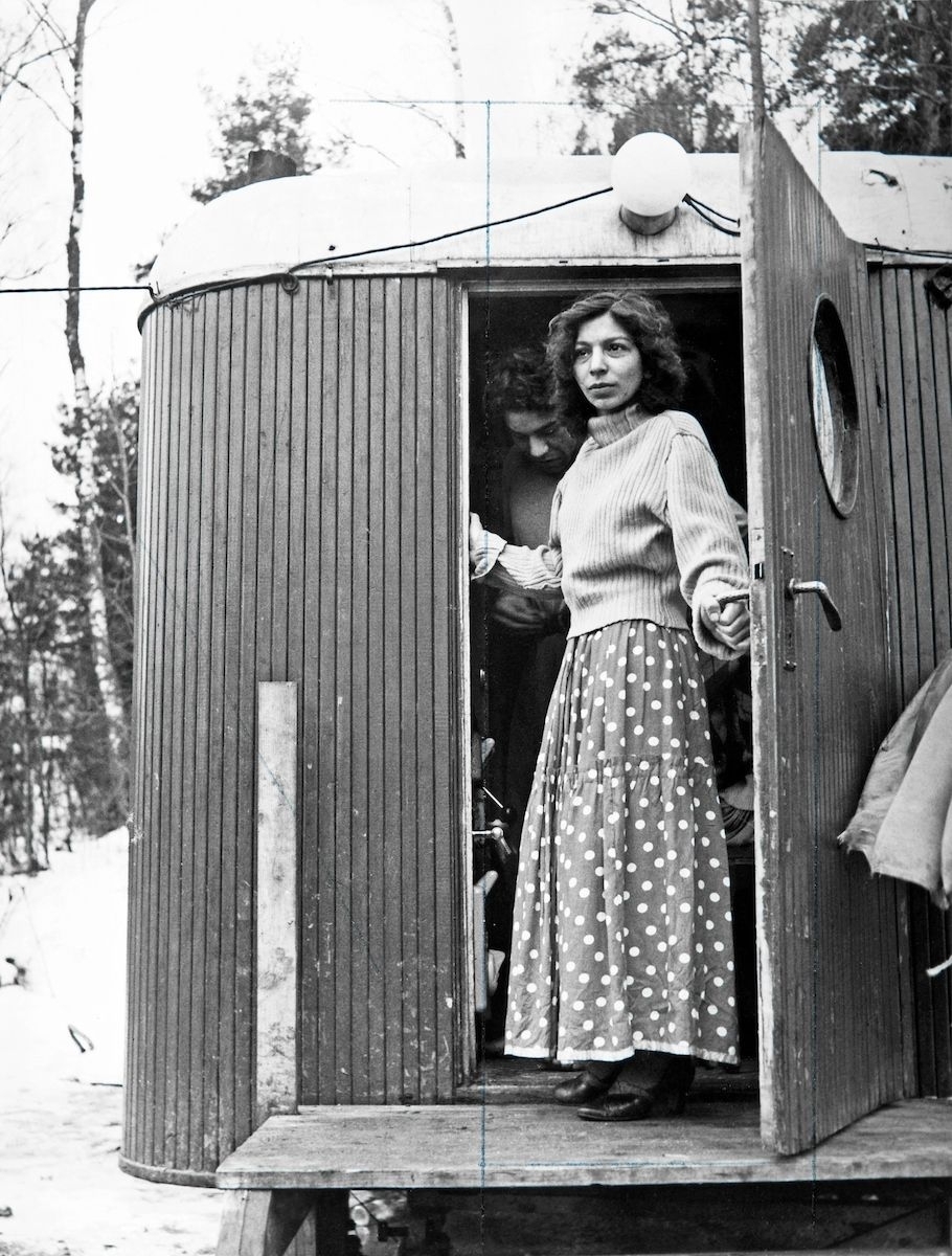I dörren till en bostadsvagn i Lilla Sköndal, Stockholm, står en romsk kvinna och blir fotograferad. En tidning gör ett reportage angående ett rapporterat slagsmål i det romska lägret, men de boende är skeptiska till att tala med reportarna.