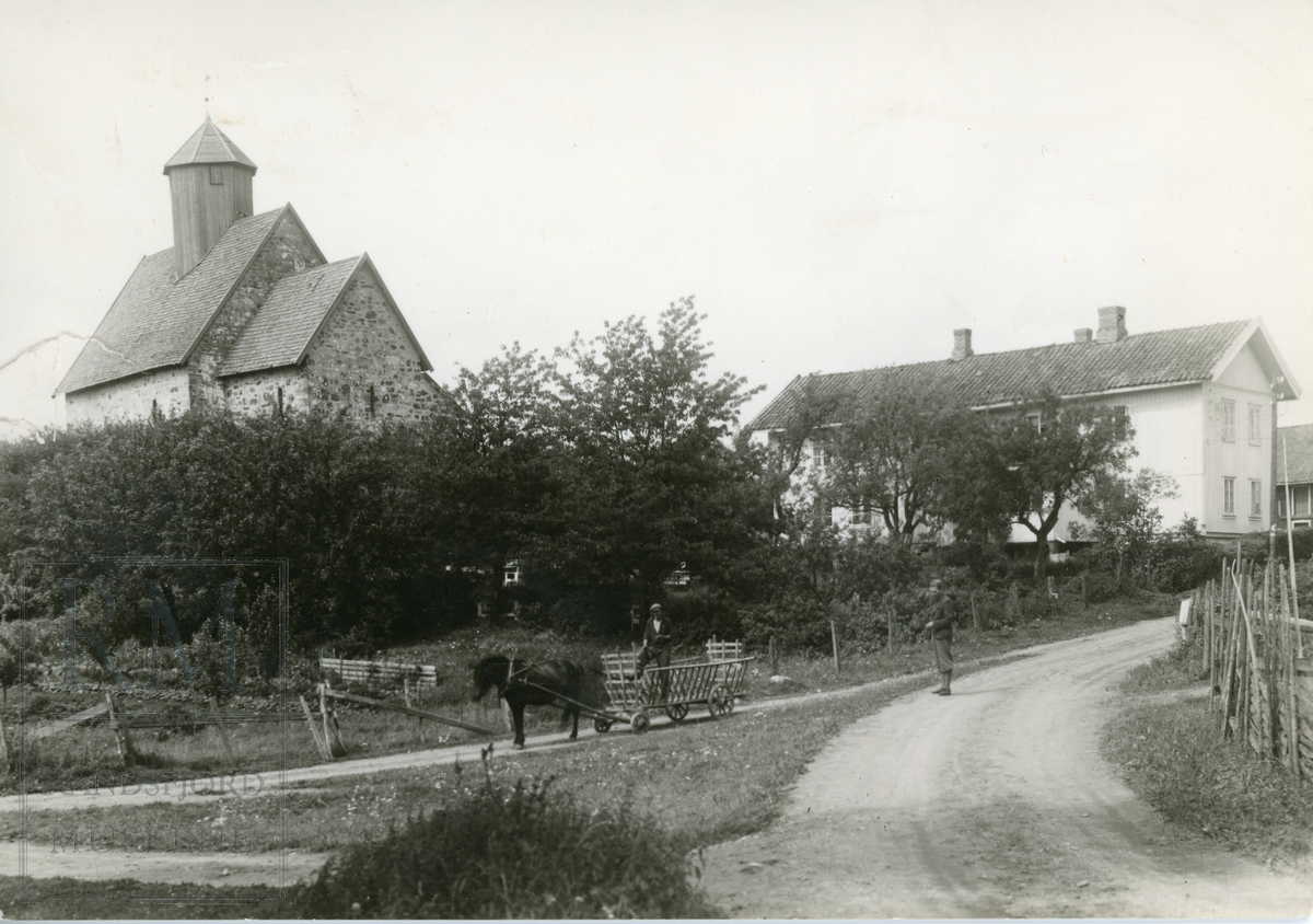 Tingelstad gamle kirke med Tingelsted pensjonat. Hest med høyvogn og kjørekar i veikryss.