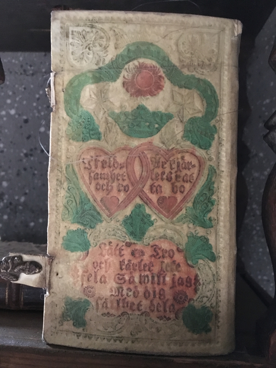 Psalmbok, brudbok, med evangeliebok och epistlar, 2 spännen.
"Den Swenska Psalmboken" i 1695 års utgåva.
Vitt skinnband med pressad och målad dekor i grönt och rött, samt text. (794 sidor)