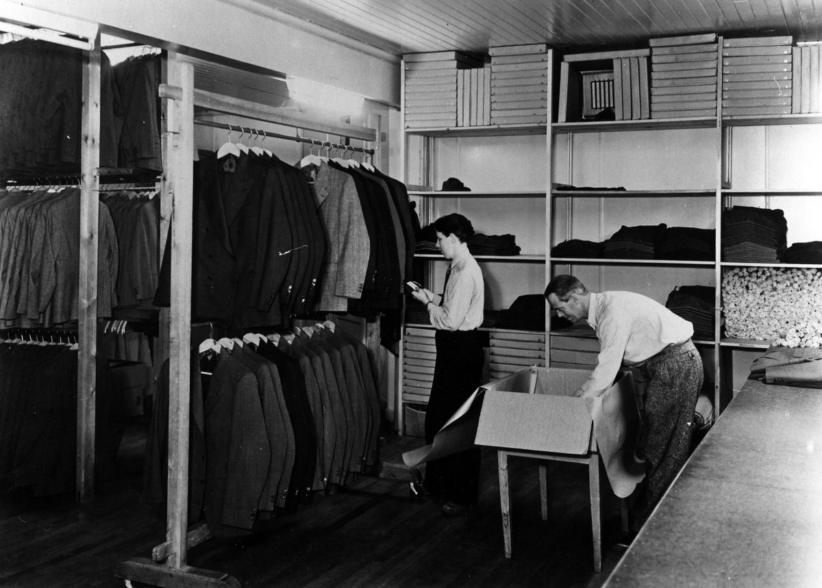 Två män packar och inventerar kläder på Drabant AB:s färdiglager.
