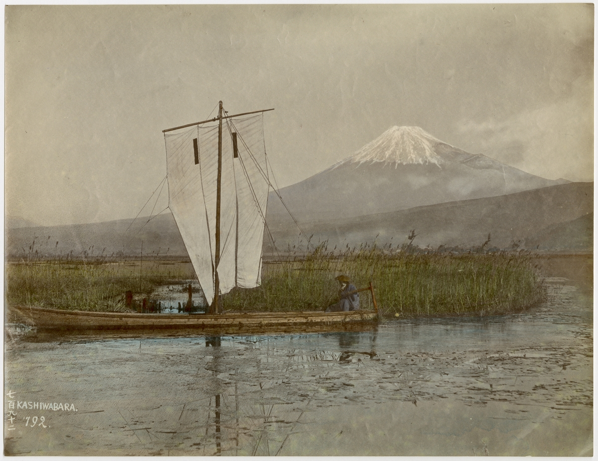 Ett kolorerat fotografi föreställandes ett landskap i Japan, troligen Mount Fuji.