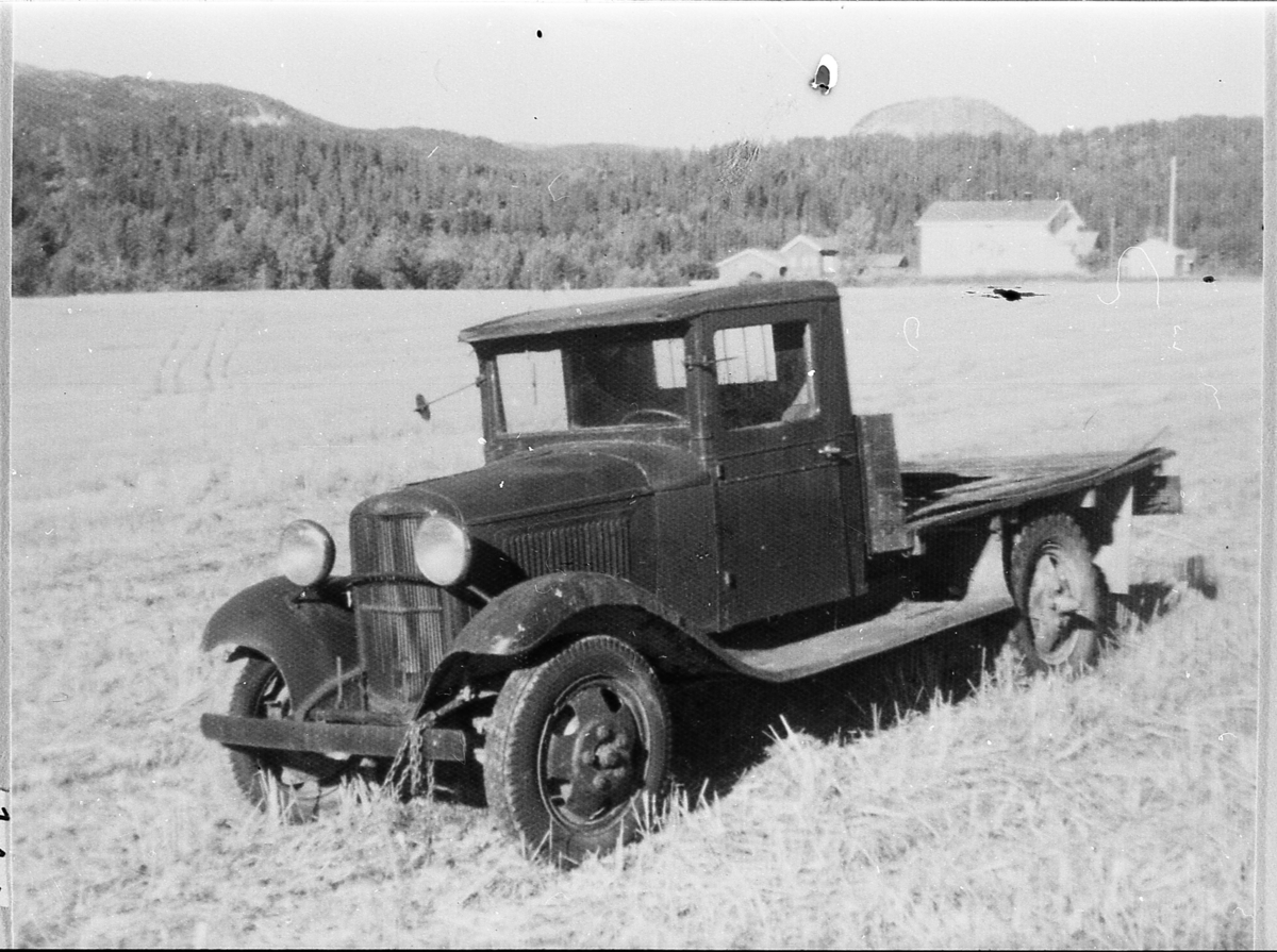 Lastebil, Ford A, 1933-modell, drevet med generator. Eidal skole i bakgrunnen.
