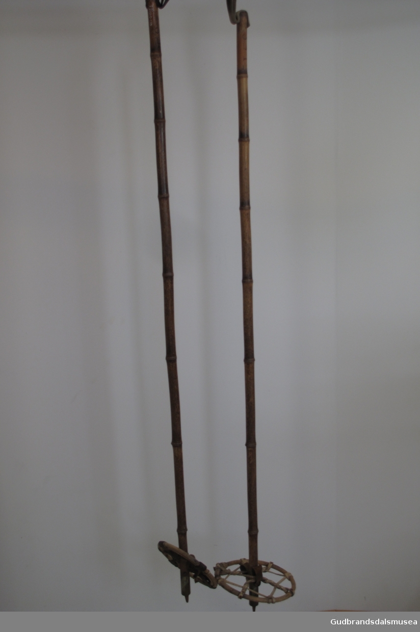 Skistaver i bambus med trinser i tre festet med lærstropper. pigg i jern. 10 cm langt messingbeslag rundt stokken nederst.