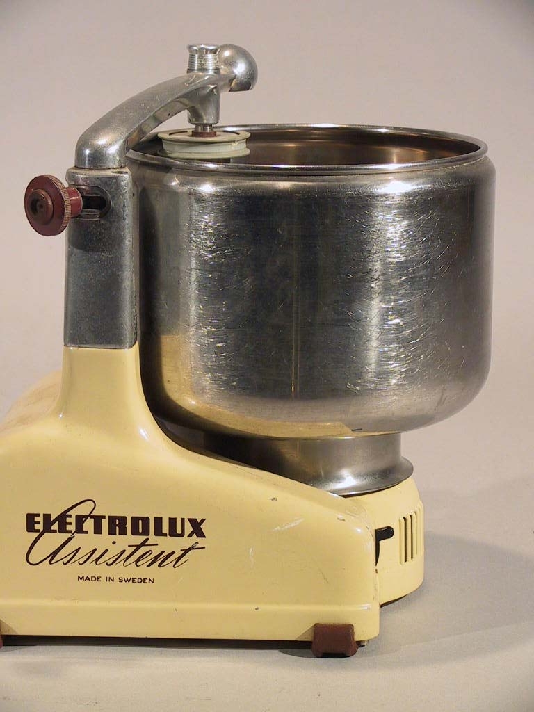 Electrolux köksmaskin Assistent i bengul färg och med Assistent logotypen på sidan. Kniv och rulle är i trä. Detta är mod N4 som har ett kompaktare motorstativ och mixerurtag.