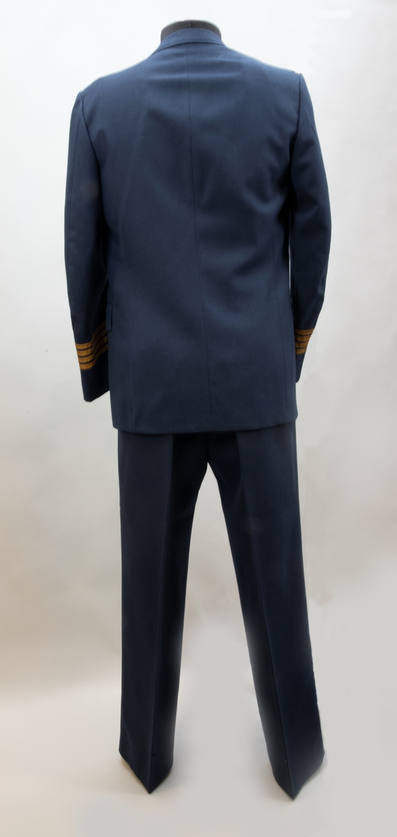 Uniform av mellanblått diagnaltyg, bestående av kavaj med 4 x 10 mm gul slät galon på ärmarna, samt byxa.
Kavaj: Storlek A50.