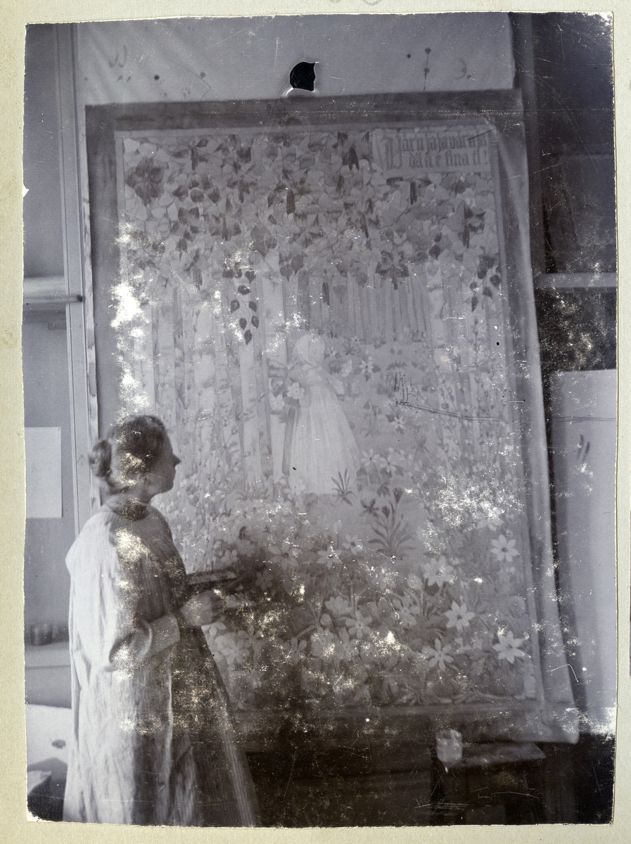 Stockholm. 
Kvinna målar tavla med flicka och blommor. 1901.