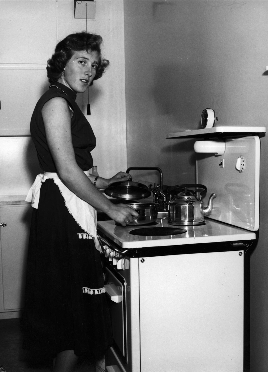 Kvinne ved komfyren på kjøkkenet i leiligheten på Sellebakk utenfor Fredrikstad.