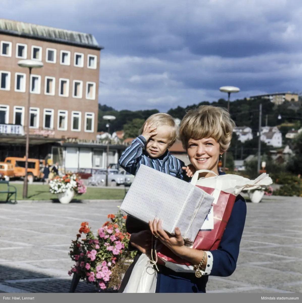Kvinna med pojke i famnen fotograferade vid Stadshusplatsen i Mölndal, 17/9 1968.
