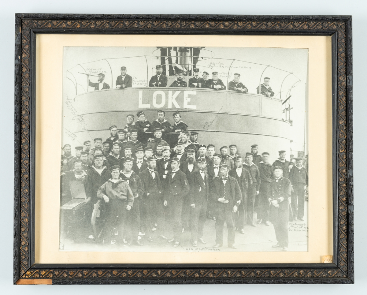 Denna gruppfoto föreställer manskapet ombord på monitor Loke år 1877. På denna reproduktion finns namnen av flera avbildade påskriven med blyertspenna.