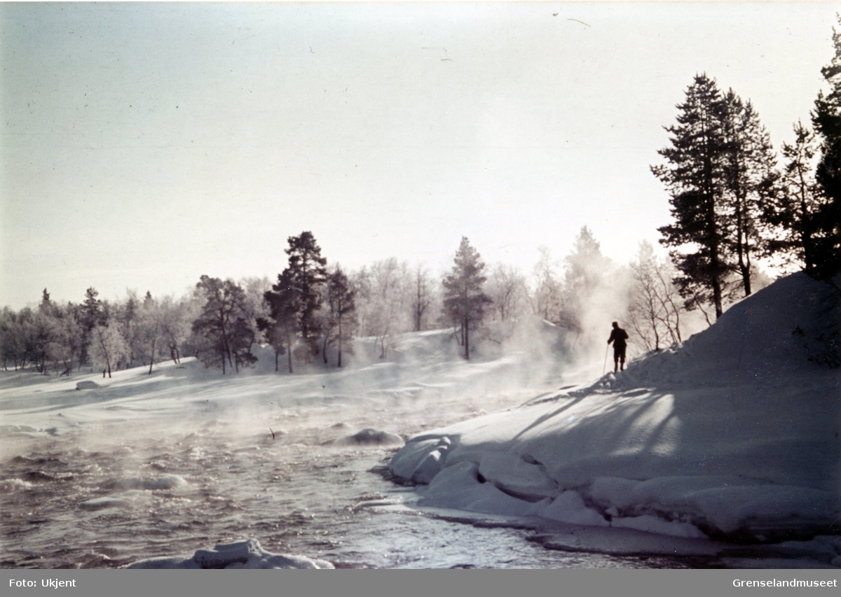 Elveleie, vinterstid i Pasvik. Skiløperen til høyre i bildet ser ut til å bære uniform.