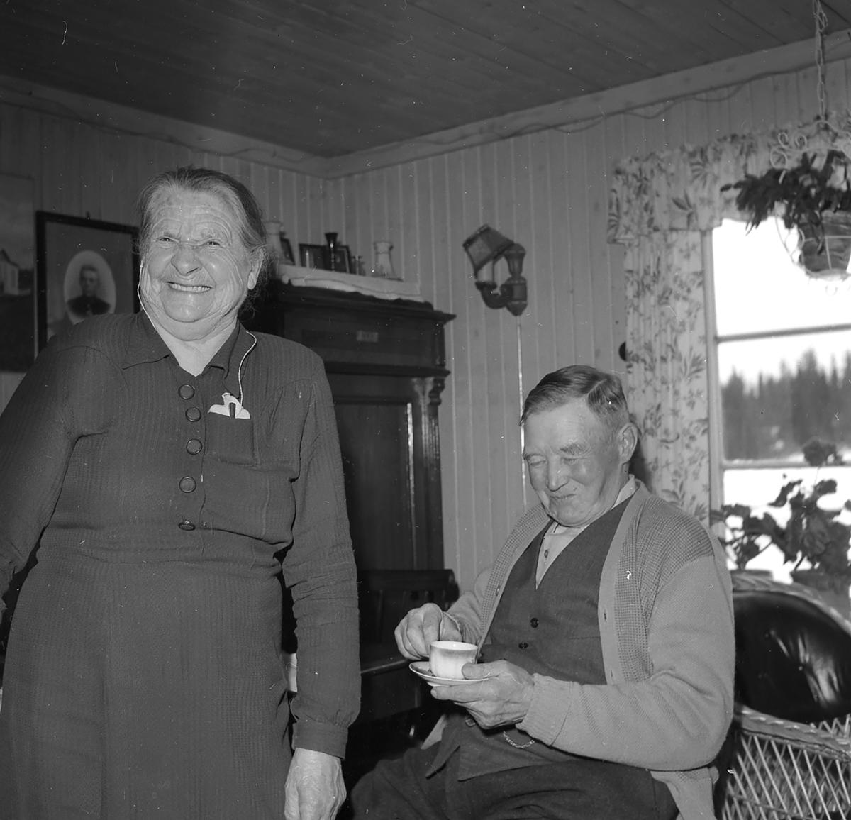 Johanne og Halvor Berg fra Hernes fotografert av Dagfinn Grønoset. Begge to ler godt mens Halvor drikker en kopp kaffe.