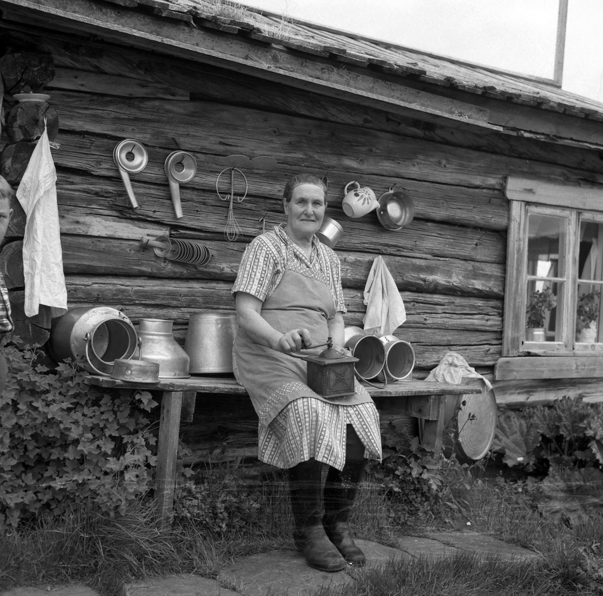 Budeie med kaffekvern sitter på en benk utenfor ei seter i  Skjæringfjell-traktene