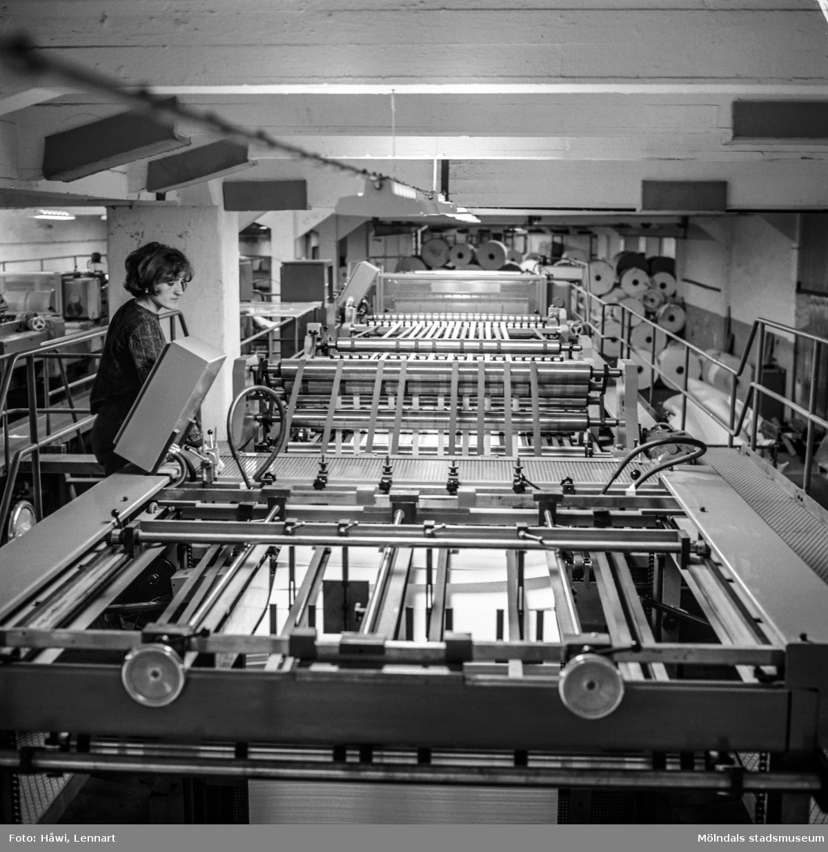Kvinna i arbete vid maskin på pappersbruket Papyrus i Mölndal 1/10 1969.