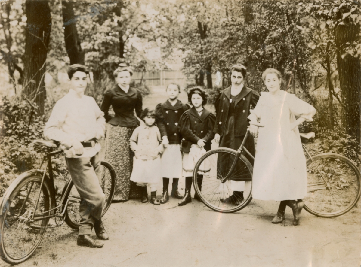 Bildet viser flere av søsknene i familien Rostin på tur i skogen. To av de eldre har sykkel. 
Fra venstre: Theodor, ukjent, muligens Victoria, Elisabeth, Julia, Florentine og Valentine.