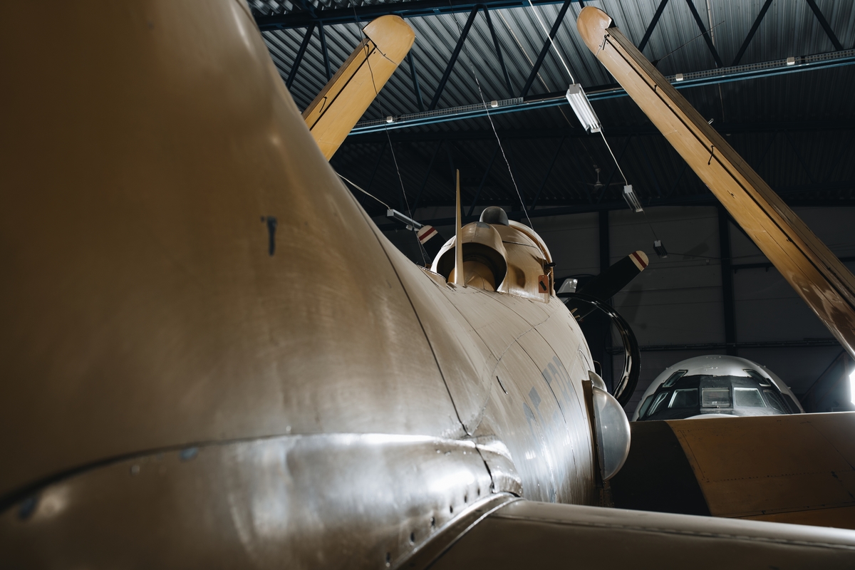 Flygplan av modell Skyraider. Enmotorigt propellerflygplan ursprungligen avsett för basering på hangarfartyg. Gulmålat, något nött med genomslag av Royal Navys marinblå kamouflage. Märkning på flygkroppens sidor: "Svensk Flygtjänst AB".